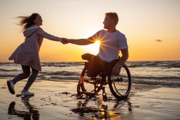 Turisti che usufruiscono di una spiaggia completamente accessibile alle persone in sedia a rotelle