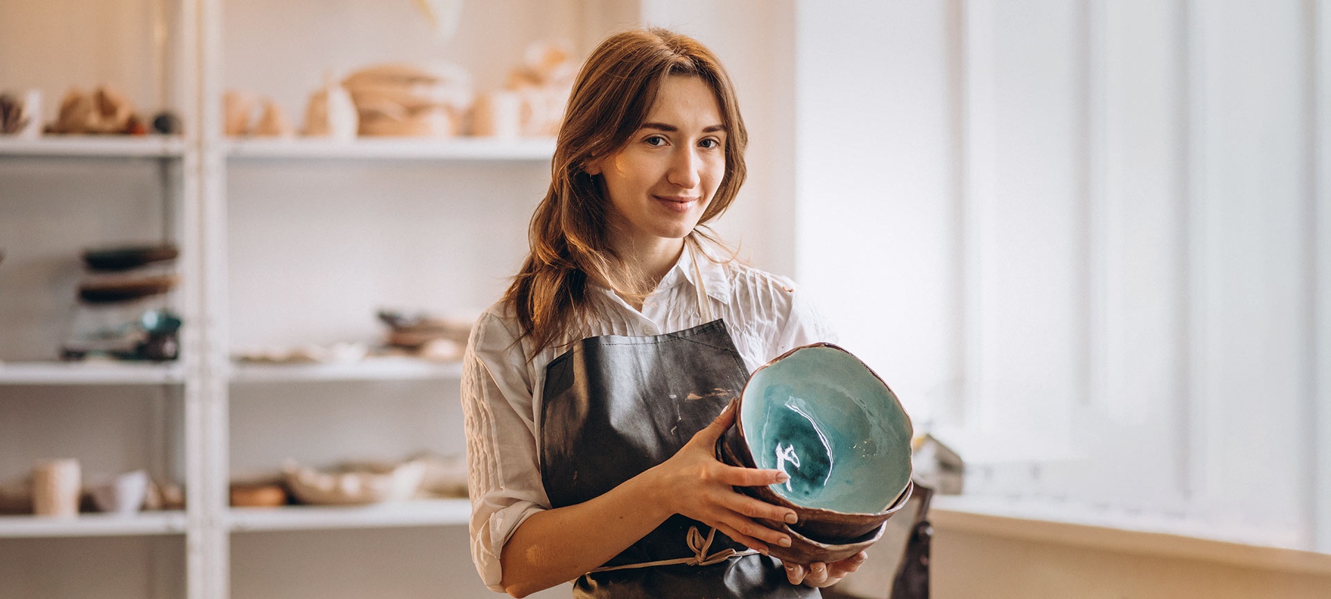 Craftswoman in pottery shop