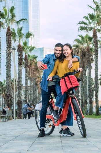 Touristen auf dem Fahrrad auf der Barceloneta-Promenade in Barcelona, Katalonien