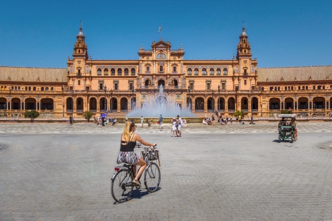 Touristen mit Fahrrädern auf der Plaza de España in Sevilla, Andalusien