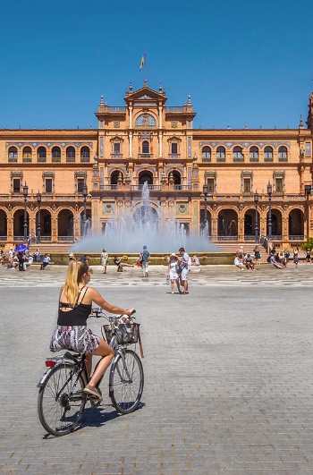 Touristen mit Fahrrädern auf der Plaza de España in Sevilla, Andalusien