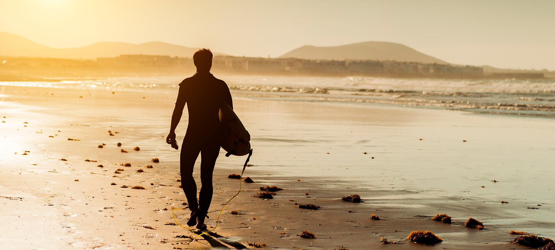 Surfer in Lanzarote at sunset Surfer in Lanzarote at sunset