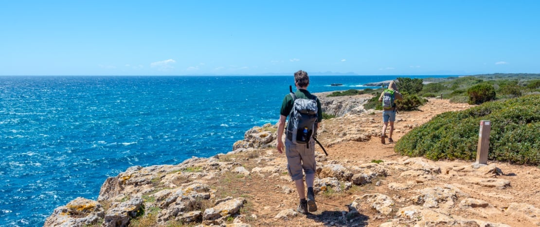 Tourists on the Camí de Cavalls in Menorca, Balearic Islands