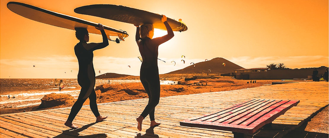 Surfers head to Medano beach in Tenerife, Canary Islands