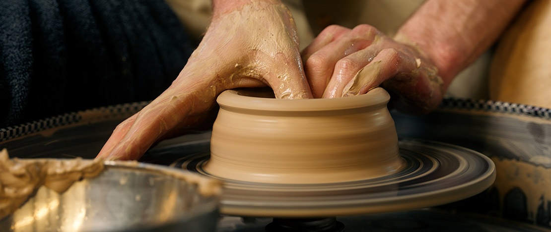 Un artigiano lavora l'argilla sul tornio per la ceramica